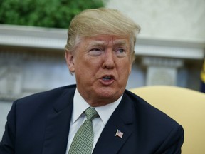 In this March 15, 2018 file photo, President Donald Trump talks with reporters during a meeting in the Oval Office of the White House in Washington. A former Playboy model who claimed she had an affair with President Donald Trump is seeking to invalidate an agreement that prohibited her from discussing the relationship. The woman, Karen McDougal, filed a lawsuit Tuesday, March 20  in Los Angeles against the company that owns supermarket tabloid National Enquirer.