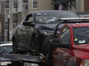 Bullet holes appear on a vehicle as it is towed away in San Francisco, Wednesday, March 7, 2018. San Francisco police say officers who were investigating an armed robbery shot and killed a man who was hiding in the trunk of a car on Tuesday night.