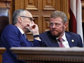 Lt. Gov. Casey Cagle and Gov. Deal's chief of staff Chris Riley confer in the senate before the senate went into recess and the Rules Committee stripped the Delta tax cut from legislation. Gov. Nathan Deal and legislative leaders had hoped they could make a deal Wednesday, Feb. 28, 2018, on the Delta fuel tax legislation - which also includes a state income tax rate cut.