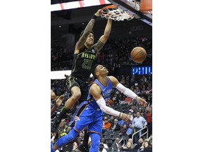 Atlanta Hawks forward John Collins (20) dunks against Oklahoma City Thunder guard Russell Westbrook during the first quarter of an NBA basketball game, Tuesday, March 13, 2018, in Atlanta.