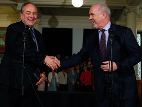 B.C. NDP Leader John Horgan, right, and B.C. Green Party Leader Andrew Weaver shake hands after signing an agreement on creating a minority government at the provincial Legislature in Victoria, B.C., on May 30, 2017.