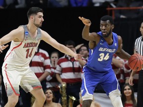 Buffalo forward Ikenna Smart (34) looks to pass around Arizona center Dusan Ristic (14) during the first half of a first-round game in the NCAA men's college basketball tournament Thursday, March 15, 2018, in Boise, Idaho.