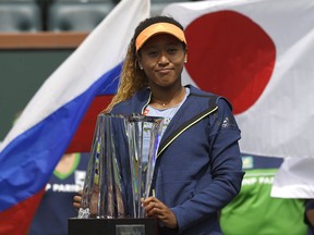 Naomi Osaka, of Japan, poses with her trophy after defeating Daria Kasatkina, of Russia, in the women's final at the BNP Paribas Open tennis tournament, Sunday, March 18, 2018, in Indian Wells, Calif. Osaka won 6-3, 6-2.
