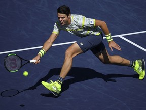 Milos Raonic, of Canada, returns a shot against Sam Querrey during the quarterfinals of the BNP Paribas Open tennis tournament, Friday, March 16, 2018, in Indian Wells, Calif.