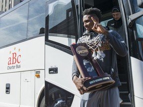 Donte Ingram and his Loyola  teammates step off the bus with the NCAA South Regional Championship trophy while greeting fans and members of the press, Sunday, March 25, 2018 in Chicago.