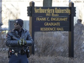 An Evanston police officer looks around at Northwestern University Engelhart graduate residence hall in Evanston, Ill., Wednesday, March 14, 2018. Police said the report of a gunman at Northwestern University was a hoax and "swatting incident." Police said they found no evidence after reports of shots fired on the campus.