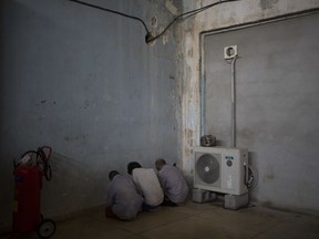 FILE - In this Oct. 3, 2017 file photo, displaced men from Hawija sit facing a wall in order not to see security officers, who will try to determine if they were associated with the Islamic State group, at a Kurdish screening center in Dibis, Iraq. An analysis by the Associated Press of a spreadsheet listing all 27,849 people imprisoned in Iraq as of late January 2018, shows that Iraq has detained or imprisoned more than 19,000 people accused of connections to IS or other terror-related offenses. More than 3,000 people have been sentenced to death.