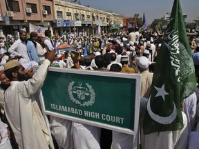 FILE - In this Oct. 11, 2011, file photo, supporters of Pakistani religious groups gather outside the Islamabad High Court in Islamabad, Pakistan. Rights activists in Pakistan expressed concern on Sunday, March 11, 2018 over a Islamabad High Court ruling that would require people to declare their religion on all official documents, saying it could lead to the persecution of minorities, particularly adherents of the Ahmadi faith.