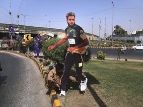 A Pakistani worker fixes a cut-out of a cricket player displayed along roadside in preparation of the upcoming Pakistan Super League final in Karachi, Pakistan, Saturday, March 24, 2018. Pakistan's biggest city will witness a high-profile cricket match for the first time in nine years on Sunday when the Pakistan Super League final is staged amid heavy security at a newly renovated National Stadium in Karachi.