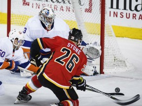 Goaltender Christopher Gibson of the New York Islanders goes low as Michael Stone of trhe Calgary Flames battles defenceman Adam Pelech in front of the goal during NHL action Sunday at the Scotiabank Saddledome. Gibson had 50 saves in a 5-2 Islanders victory, snapping an eight-game losing streak in the process.