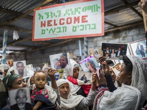 Members of Ethiopia's Jewish community hold pictures of their relatives in Israel, below a banner reading "Welcome" in Amharic, English and Hebrew, during a solidarity event at the synagogue in Addis Ababa, Ethiopia Wednesday, Feb. 28, 2018. Hundreds of Ethiopian Jews gathered at the synagogue to express concern that Israel's proposed budget removes the funding to help them immigrate to reunite with relatives in that country, as representatives said they will stage a mass hunger strike if Israel eliminates the funding.