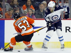 Shayne Gostisbehere of the Flyers, left, strips the puck away from the Winnipeg Jets' Patrik Laine during the first period of their game Saturday in Philadelphia. The Flyers won 2-1.