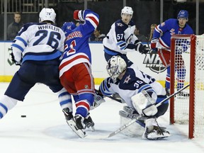 Blake Wheeler and goaltender Steve Mason of the Jets keep the Rangers' David Desharnais from getting to the puck in front of the Winnipeg crease during the second period of their game in New York on Tuesday night.