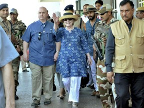Former U.S. Secretary of State Hillary Clinton, center, waves as she comes out of the Jodhpur airport upoon her arrival in Jodhpur, Rajasthan state, India, Tuesday, March 13, 2018.