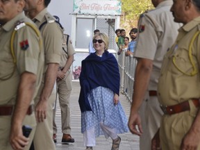 In this Thursday, March 15, 2018 photo, former U.S. Secretary of State Hillary Clinton, center, arrives at the departure terminal of Jodhpur airport in Rajasthan state, India.