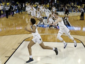 Michigan guard Jordan Poole (2) is chased by teammates after making a 3-point basket at the buzzer to win an NCAA men's college basketball tournament second-round game against Houston on Saturday, March 17, 2018, in Wichita, Kan. Michigan won 64-63.