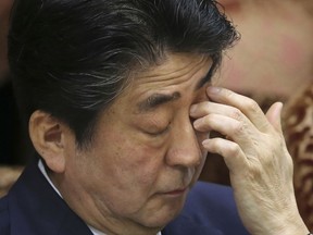 Japanese Prime Minister Shinzo Abe scratches his eyelid during a meeting of the upper house budget committee at the parliament in Tokyo, Monday, March 19, 2018. Support ratings for Abe have plunged amid a widening school land sale scandal linked to his wife, possibly risking chances for his third term in party leadership. Abe's Cabinet has come under fire especially after Finance Ministry officials acknowledged tampered land deal documents, including deleting references to First Lady Akie Abe.