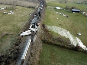 Train cars are spilled sideways across tracks and on nearby hills following an accident in Georgetown, Ky., Monday, March 19, 2018.  Two freight trains collided and derailed shortly before midnight, injuring four people and igniting a fire that forced nearby residents to evacuate, authorities said Monday.