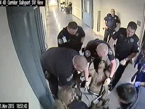 FILE - In this Nov. 11, 2015, file frame from jailhouse surveillance video recorded at Denver's Downtown Detention Center, released by the Denver Department of Safety via the law firm Killmer, Lane & Newman, LLP, 50 year-old homeless man Michael Marshall is wheeled out in a restraint chair by Denver sheriff's deputies after becoming aggressive with another inmate. He choked on his own vomit, lost consciousness and died later at a hospital. A police watchdog says the sheriff's department mishandled its internal investigation of the jail staff involved. (Denver Department of Safety/Killmer, Lane & Newman, LLP via AP, File)