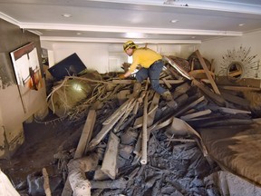 FILE - In this Jan. 13, 2018, file photo provided by the Santa Barbara County Fire Department, Santa Barbara County Firefighter Vince Agapito searches through a Montecito, Calif., home that was destroyed by deadly mudflow and debris early Tuesday morning following heavy rainfall. Authorities are urging people living in an area devastated by mudslides to evacuate ahead of a strong Pacific storm that forecasters say is likely to bring an extended period of rain and the threat of flooding and debris flows. Santa Barbara County issued a mandatory evacuation order Monday, March 19, 2018, affecting about 30,000 people, including the community of Montecito, where 21 people were killed by a massive mudslide in January.