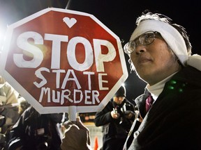 FILE - In this Dec. 12, 2005, file photo, Barbara Chan protests the execution of Stanley "Tookie" Williams, the founder of the Crips gang, outside of San Quentin State Prison in San Quentin, Calif. The battle over California's voter-backed effort to resume executions is beginning in earnest, with state officials and death penalty supporters moving to end court orders that have blocked executions since 2006. State officials and a former NFL player whose family was murdered are asking a Marin County judge on March 28, 2018, to lift his injunction, arguing that California now has the necessary regulations switching to a single lethal dose of powerful barbiturates to execute condemned inmates.