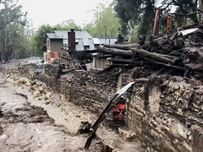This photo from video provided by the Santa Barbara County Fire Department shows Montecito Creek flowing alongside debris left over from January mudslides in Montecito, Calif., Wednesday, March 21, 2017. A strong Pacific storm dropped heavy rain Wednesday on a swath of coastal California, where thousands of people have been evacuated because of the threat of debris flows and mudslides from wildfire burn areas.