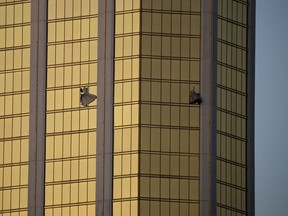 FILE - In this Oct. 2, 2017 file photo, drapes billow out of broken windows at the Mandalay Bay resort and casino on the Las Vegas Strip following a mass shooting at a music festival. A Nevada judge says he'll rule this week how much media companies should have to pay to obtain police records about the Las Vegas Strip mass shooting that became the deadliest in modern U.S. history.