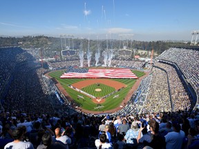 Fireworks explode during the national anthem prior to an opening day baseball game between the San Francisco Giants and the Los Angeles Dodgers, Thursday, March 29, 2018, in Los Angeles.