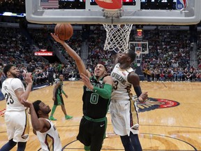 Boston Celtics forward Jayson Tatum (0) goes to the basket against New Orleans Pelicans forward Cheick Diallo in the first half of an NBA basketball game in New Orleans, Sunday, March 18, 2018.