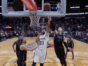 New Orleans Pelicans guard Ian Clark (23) goes to the basket between Dallas Mavericks' Dwight Powell (7) and Dirk Nowitzki during the first half of an NBA basketball game in New Orleans, Tuesday, March 20, 2018.