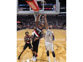 Portland Trail Blazers guard Damian Lillard (0) goes to the basket against New Orleans Pelicans forward Nikola Mirotic (3) in the first half of an NBA basketball game in New Orleans, Tuesday, March 27, 2018.