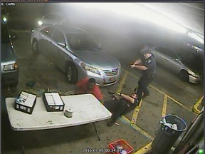 In this still image taken from security camera video provided Friday, March 30, 2018, by the Baton Rouge Police Department, officers Blane Salamoni and Howie Lake II confront Alton Sterling, left, during a struggle outside the Triple S Food Mart in Baton Rouge, La., in July 2016. On Friday, Baton Rouge Police Chief Murphy Paul fired Salamoni, who fatally shot Sterling during the struggle, a killing that set off widespread protests. (Courtesy of Baton Rouge Police Department via AP)