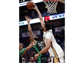 New Orleans Pelicans forward Anthony Davis blocks a shot by Boston Celtics forward Marcus Morris during the second half of an NBA basketball game in New Orleans, Sunday, March 18, 2018. The Pelicans won 108-89.