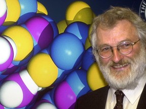 FILE - A Monday, Feb. 12, 2001 file photo ofJohn Sulston, former director of the Sanger Center and leader of the UK effort to sequence the human genome, stands infront of a picture of a model of the DNA double helix after a press conference to announce the completion of the mapping of the human genome. John Sulston, a Nobel Prize-winning British scientist who helped decode the human genome, has died. He was 75.