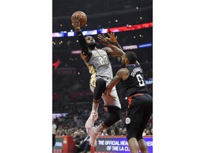 Cleveland Cavaliers forward LeBron James, left, shoots as Los Angeles Clippers guard Sindarius Thornwell defends during the first half of an NBA basketball game Friday, March 9, 2018, in Los Angeles.