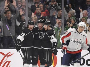 Los Angeles Kings center Jeff Carter, second from left, celebrates his goal with center Tyler Toffoli, left, and left wing Tanner Pearson, second from right, as Washington Capitals left wing Jakub Vrana, of the Czech Republic, skates off during the first period of an NHL hockey game, Thursday, March 8, 2018, in Los Angeles.