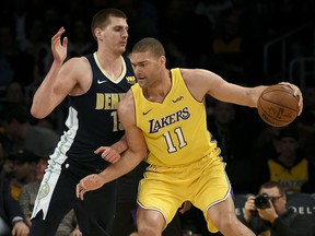 Los Angeles Lakers center Brook Lopez, right, posts up on Denver Nuggets center Nikola Jokic during the first half of an NBA basketball game in Los Angeles, Tuesday, March 13, 2018.