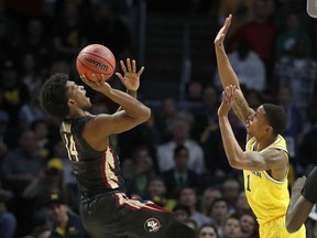 Florida State guard Terance Mann, left, shoots against Michigan guard Charles Matthews during the first half of an NCAA men's college basketball tournament regional final Saturday, March 24, 2018, in Los Angeles.