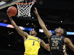 Michigan guard Charles Matthews (1) shoots against Florida State forward Mfiondu Kabengele (25) during the first half of an NCAA men's college basketball tournament regional final Saturday, March 24, 2018, in Los Angeles.
