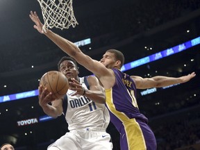 Dallas Mavericks guard Yogi Ferrell (11) attempts a shot as Los Angeles Lakers center Brook Lopez (11) defends during the first half of an NBA basketball game in Los Angeles on Wednesday, March 28, 2018.