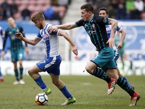 Wigan Athletic's Michael Jacobs, left, and Southampton's Pierre-Emile Hojbjerg battle for the ball during the English FA Cup, quarterfinal match at the DW Stadium, Wigan, England, Sunday March 18, 2018.