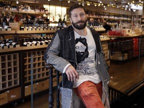 In this photo taken on Friday, March 16, 2018, Russian entrepreneur Yevgeny Chichvarkin poses for a photograph in his wine shop Hedonism, in London. Amid the rising diplomatic tensions, some Russians feel they themselves trapped between stereotypes and political outrage. Chichvarkin, a one-time mobile phone entrepreneur and Kremlin critic who has lived in London for a decade, says he feels a bit less welcome. Even though he runs a an exclusive wine shop in the tony Mayfair district, plans for a new project that will create 200 jobs and contributes to art and society, his neighbors recently rejected his offer to install a trampoline in the local park.