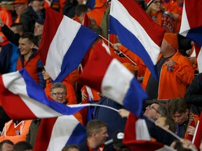 Dutch fans wave flags before the international friendly soccer match between the Netherlands and England at the Amsterdam ArenA in Amsterdam, Netherlands, Friday, March 23, 2018.