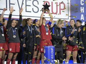 FILE - In this Wednesday, March 7, 2018 file photo, United States midfielder Carli Lloyd, center, lifts the championship trophy with teammates after defeating England 1-0, to win the SheBelieves Cup women's soccer tournament in Orlando, Fla. The United States stays top of the FIFA women's world rankings after winning the SheBelieves Cup, and England goes above Germany into second. The Americans went unbeaten through the four-team round-robin tournament it hosted this month.