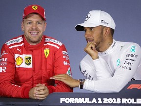 FILE - In this Saturday, March 24, 2018 file photo, Mercedes driver Lewis Hamilton, right, of Britain, and Ferrari driver Sebastian Vettel of Germany laugh during a press conference following qualifying at the Australian Formula One Grand Prix in Melbourne. Mercedes blames a bug from an offline tool for the timing error which hindered Formula One champion Lewis Hamilton's bid to win the Australian Grand Prix.