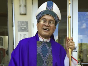 FILE - In this Nov. 2014 file photo, Archbishop Anthony Apuron stands in front of the Dulce Nombre de Maria Cathedral Basilica in Hagatna, Guam. The Vatican said Friday March 16, 2018, it had convicted the suspended Guam archbishop, who was accused of sexually abusing minors, financial mismanagement and other charges, but didn't say exactly what crimes he had committed.