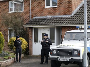 FILE - In this Tuesday, March 6, 2018 file photo, police officers stand outside the house of former Russian double agent Sergei Skripal in Salisbury, England. British police say they believe a Russian ex-spy and his daughter first came into contact with a military-grade nerve agent at their front door. Deputy Assistant Commissioner Dean Haydon says in a statement Wednesday, March 28 police are now focusing their investigation in and around Sergei Skripal's home.