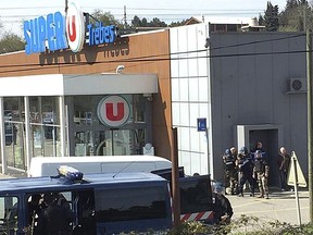 In this image provided by Newsflare/Tarbouriech Roseline police gather outside a supermarket in Trebes, southern France, Friday March 23, 2018. An armed man took hostages in a supermarket in southern France on Friday, killing two and injuring about a dozen others, police said. He had earlier opened fire on officers nearby.(Newsflare/Tarbouriech Roseline via AP)