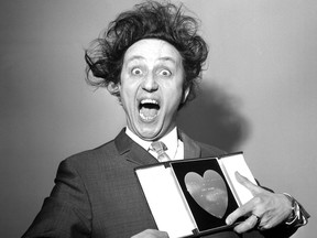 FILE - In this March 8, 1966 file photo, comedian Ken Dodd poses with his award for Show Business Personality of the Year, presented to him at the Variety Club's luncheon at the Savoy Hotel, London. British comedian Ken Dodd, whose seven-decade career stretched from the music-hall era to the age of social media, has died. He was 90. Publicist Robert Holmes says Dodd died Sunday, March 11, 2018 at his Liverpool home, the same house where he was born in 1927. (PA via AP, File)