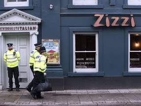 Police outside an Italian restaurant in Salisbury, England, Tuesday March 6, 2018, near to where former Russian spy double agent Sergei Skripal and his companion were found critically ill Sunday following exposure to an "unknown substance".   66-year old Skripal, and unidentified woman companion are being treated in hospital, after they were found unconscious on the park bench in Salisbury.